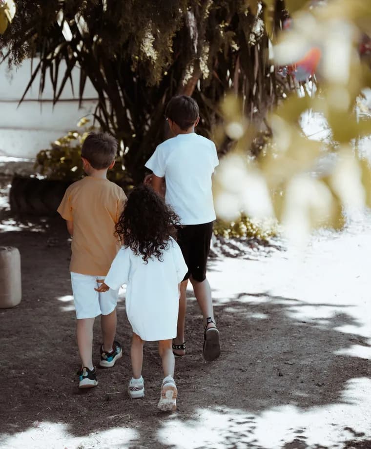 Three children walking together outdoors