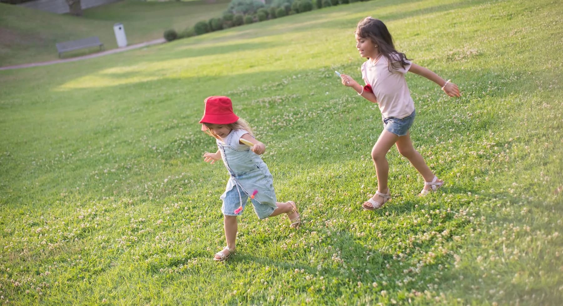 Two sisters playing together in a sunlit field